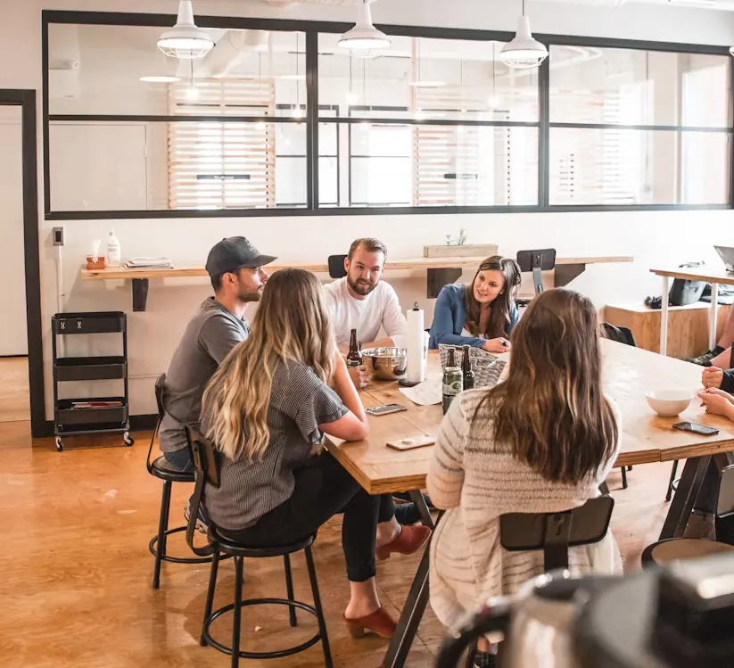 A small team talking together around a shared office table
